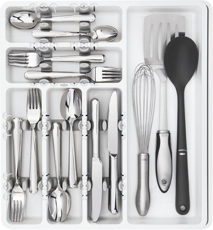White OXO drawer organizer holding forks, knives, a whisk, and a spoon